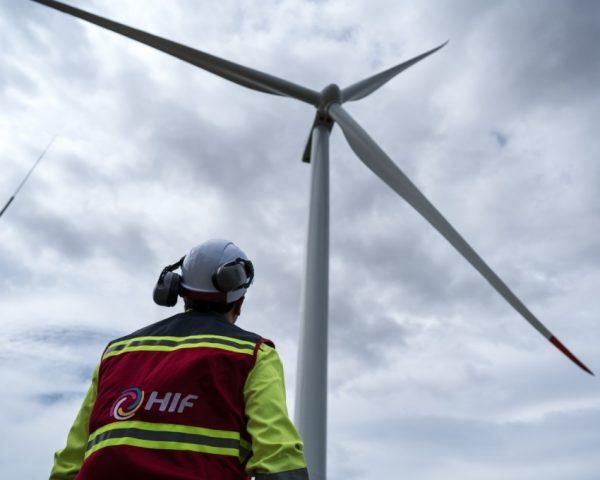 un trabajador de la energía parado debajo de aspas