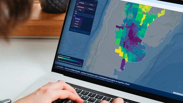 Una mano teclea en una computadora. En la pantalla se ve el mapa de Argentina. Imagen: CONICET