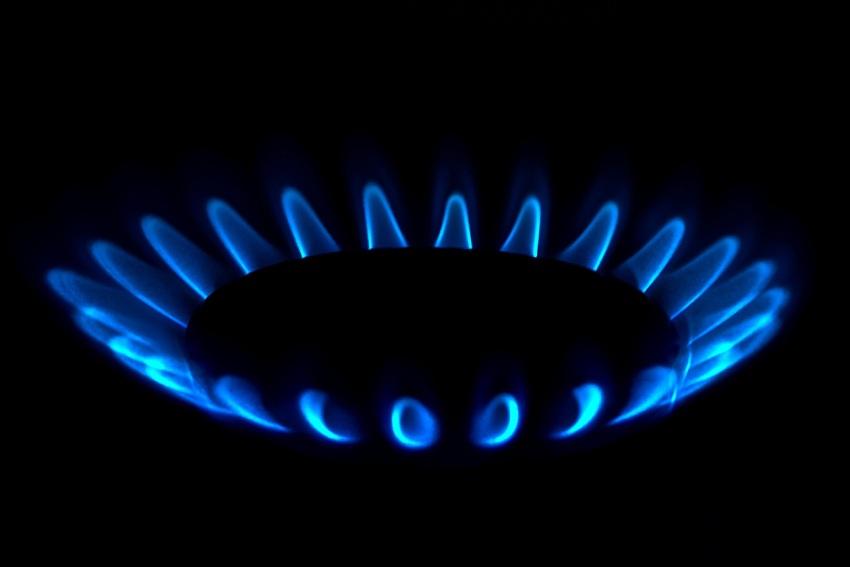 Hornalla de gas encendida color azul con un fondo negro