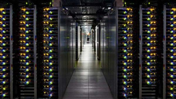 un centro de datos forma un pasillo largo y al final se observa a una persona caminando