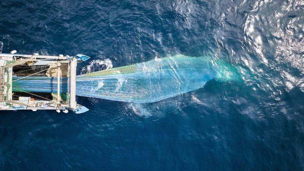 Un barco con una red de arrastre en el mar.