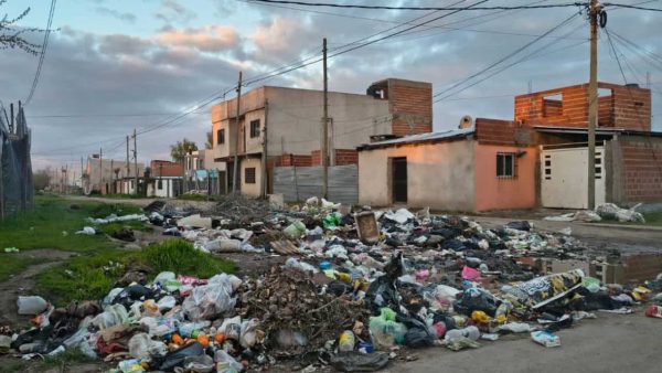bolsas de basuras tiradas en la calle y de fondo las casas del barrio Los Hornos