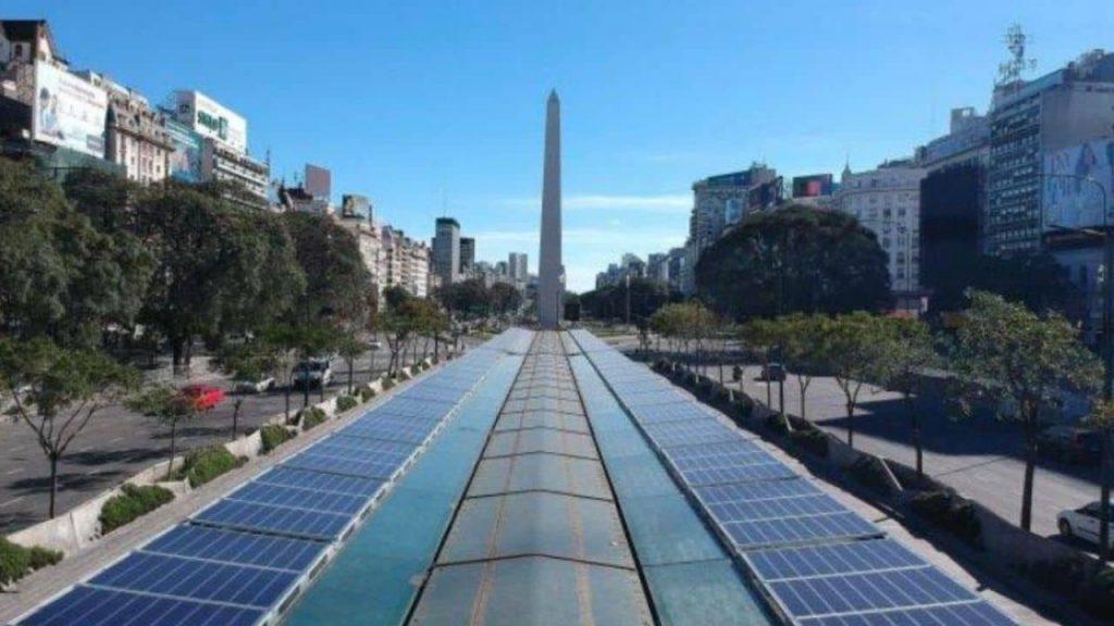 el techo de las estaciones del metro bus en 9 de julio tienen paneles solares y, de fondo, el obelisco