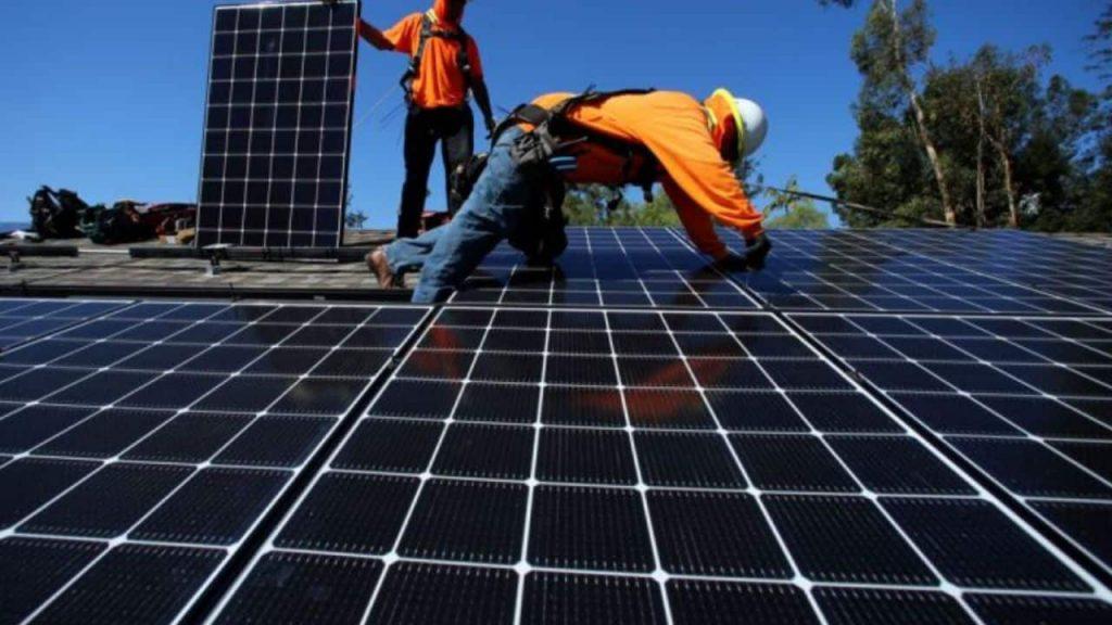 dos trabajadores cambian un panel solar