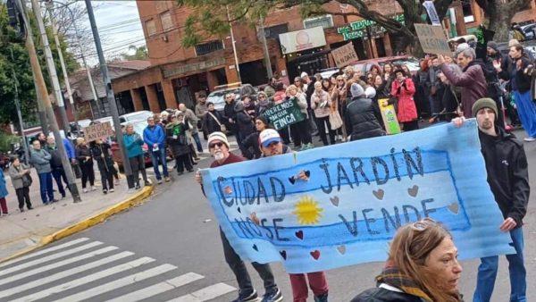 Un grupo de vecinos sostienen una bandera de argentina que dice Ciudad Jardín no se vende