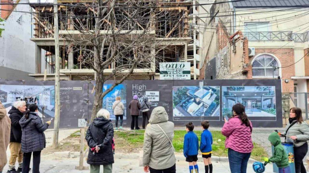 Un grupo de vecinos en la calle miran cómo se construye un edificio
