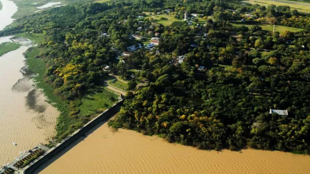 una imagen aérea de un muelle sobre el agua y un terreno firme lleno de árboles