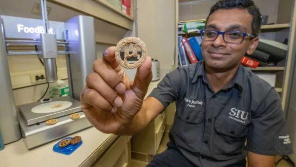 un hombre sostiene con su mano una galletita que fue creada a partir de plástico PET