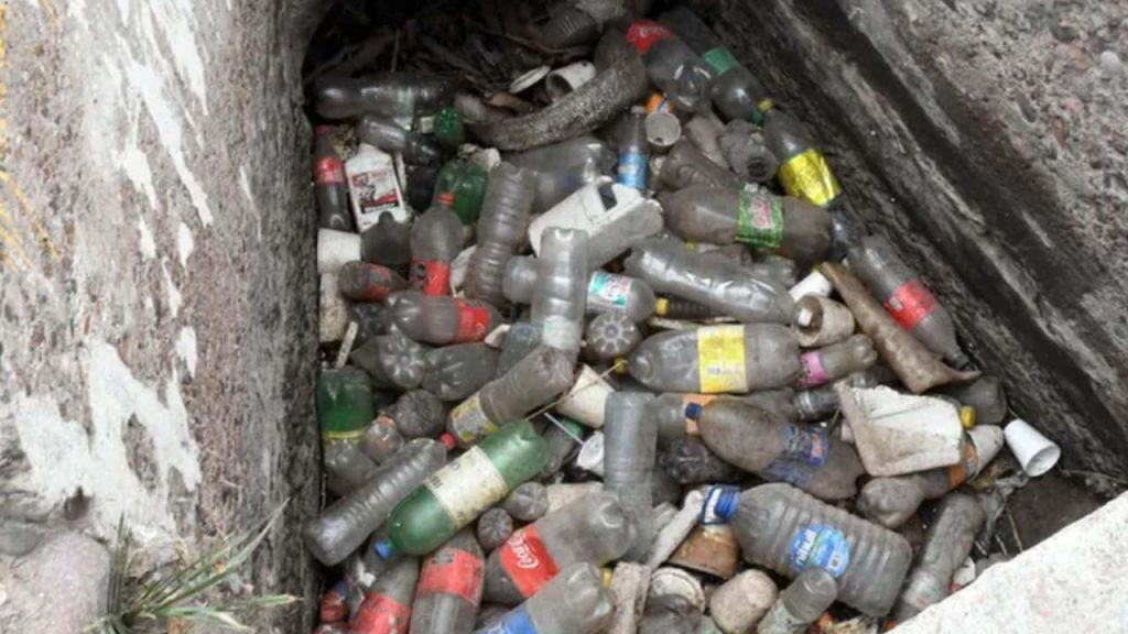 botellas y residuos entre dos paredes