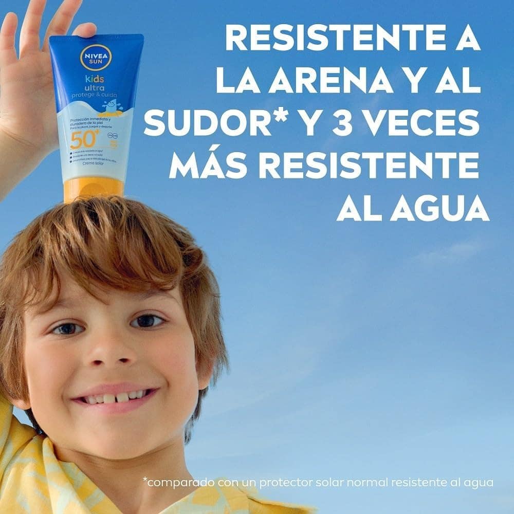una publicidad de un nene sonriente sosteniendo un protector solar en la cabeza con una de sus manos