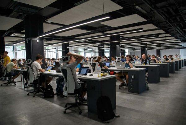 muchas personas dentro de una oficina sentadas en mesa y cada uno con sus respectivas computadoras trabajando. Imagen: Unplash