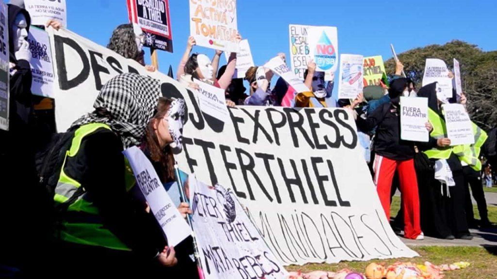 manifestantes con la cara tapada reclaman contra la presencia de Peter Thiel en Argentina