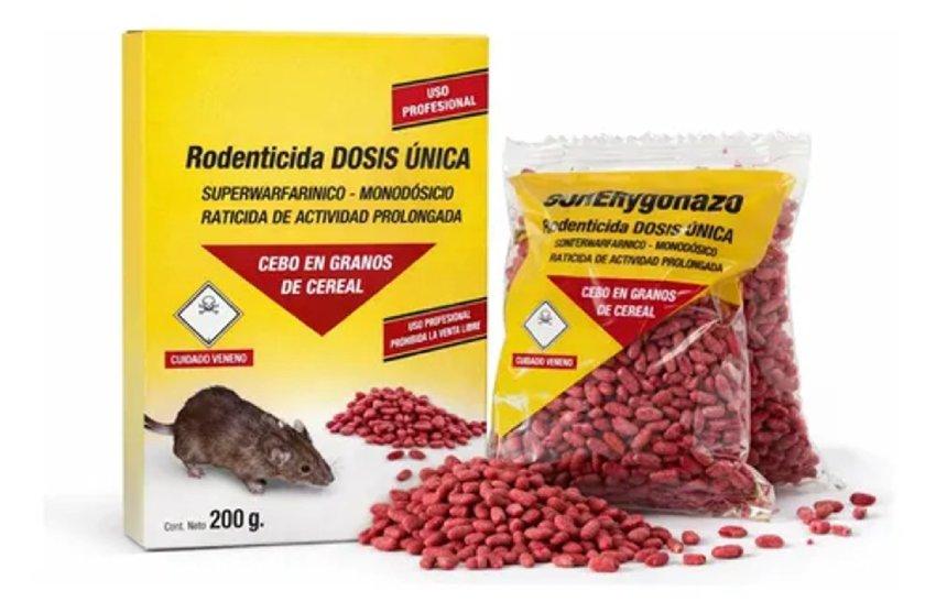 Caja y bolsa transparente de raticida SUPERCygonazo en granos de cereal de color rosado o rojo, junto a la ilustración de una rata y símbolos de advertencia de veneno, sobre un fondo blanco neutro