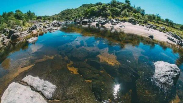 el río Quillinzo ocupa el centro de la imagen y se observan árboles y pasto de fondo