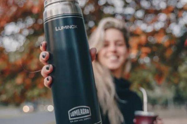 Una chica sostiene un termo y en la otra mano un mate
