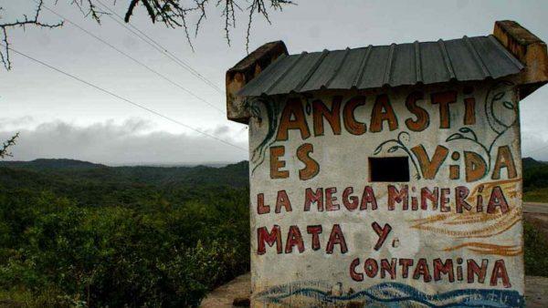 una leyenda escrita sobre la pared de una casilla: "Ancasti es vida. La megaminería mata y contamina"