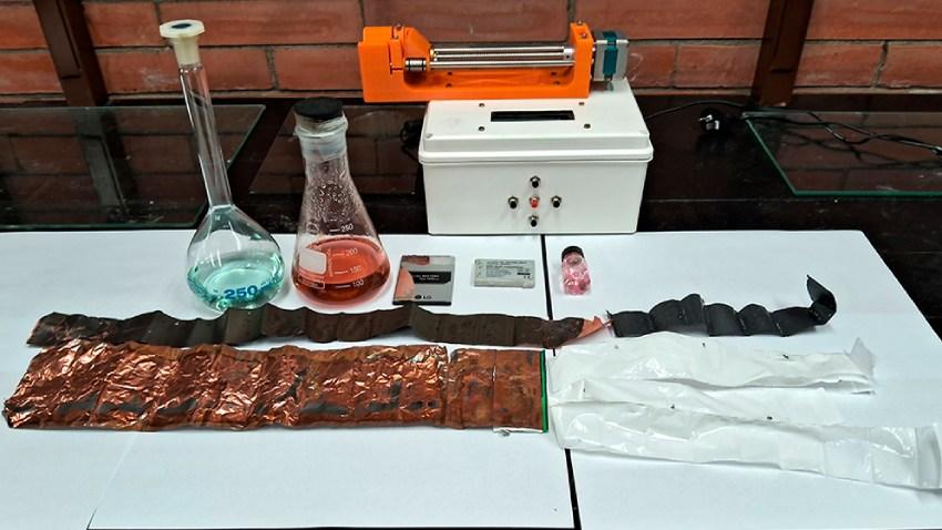 Tiras de electrodos y membranas de baterías de litio, junto a extracciones de cobalto y níquel (líquidos coloreados) recuperados. Las esferas son cápsulas poliméricas de cobalto