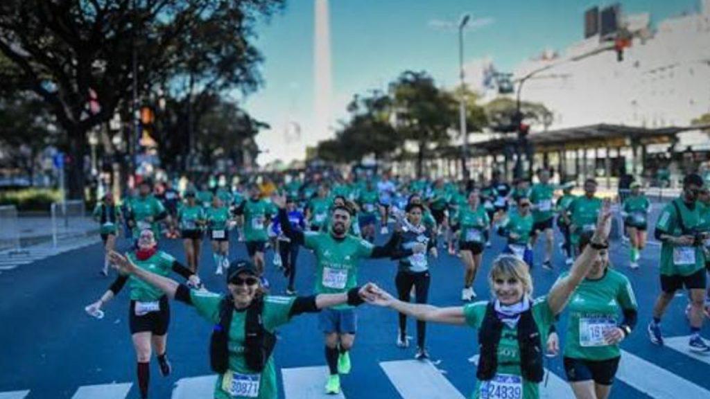 maratonistas corriendo por la 9 de julio, levantando los brazos para la foto y el Obelisco de fondo