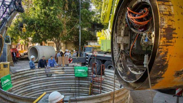 Una obra hidráulica con maquinaria pesada, una excavación circular y operarios durante los trabajos de construcción