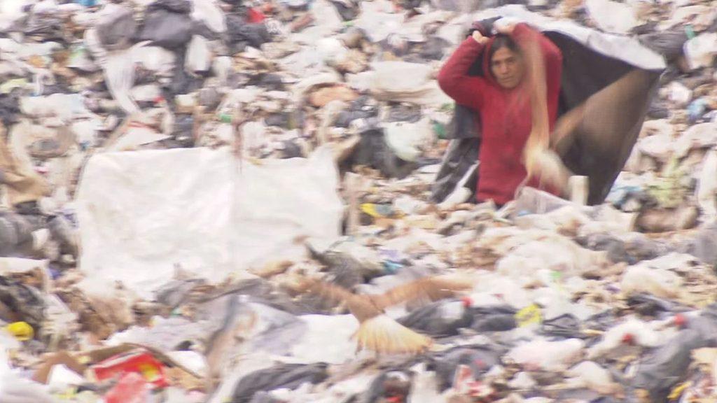 Una trabajadora informal recupera residuos en el basural a cielo abierto de Miramar, rodeada de basura acumulada