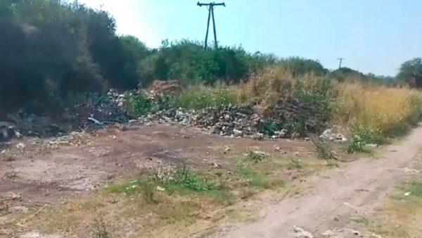 Basural a cielo abierto en Pueblo Brugo, Entre Ríos, con residuos acumulados junto a la vegetación y un camino de tierra