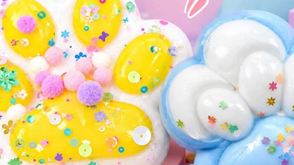 Juguetes blandos con forma de nube y de figura amarilla, decorados con pequeños adornos de colores y pompones