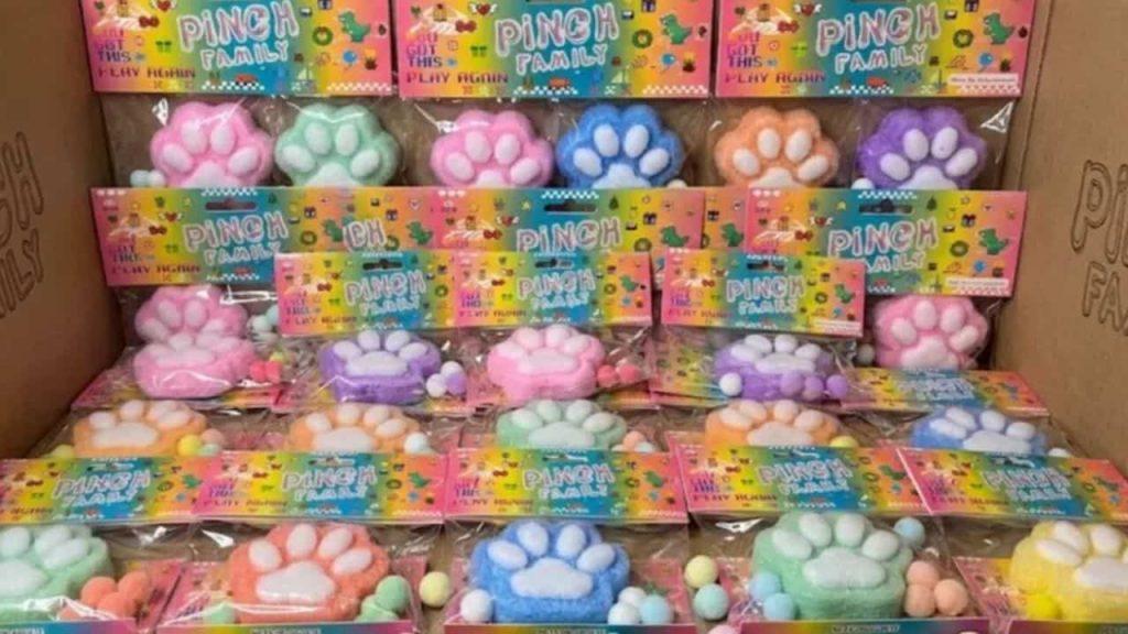 Juguetes sensoriales Pinch Family con forma de huellas de animales, en distintos colores pastel y presentados en envases individuales dentro de una caja