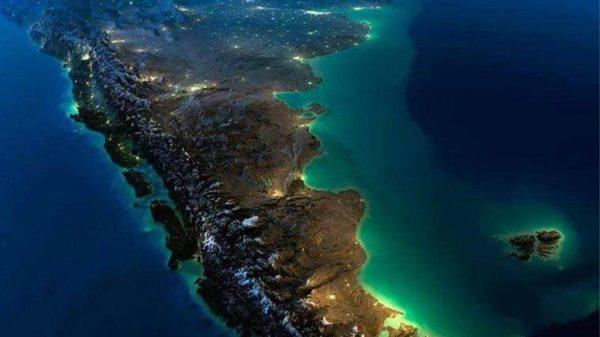 Vista satelital nocturna en 3D del extremo sur de América del Sur, que muestra el relieve montañoso de los Andes, la costa atlántica iluminada y las islas Malvinas en el océano.