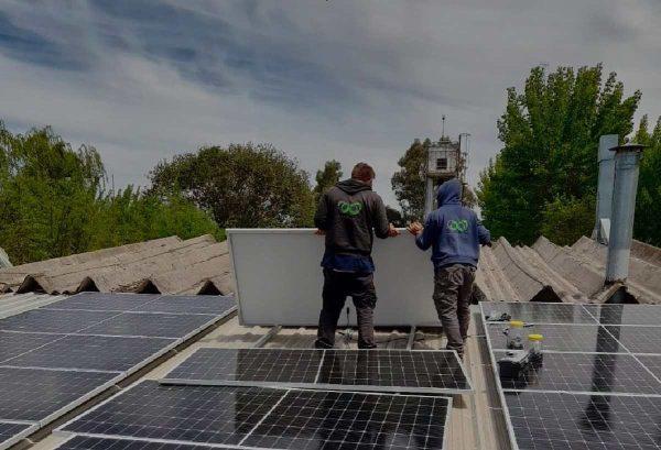 Trabajadores instalando paneles solares en un techo como parte de un proyecto de generación de energía renovable.