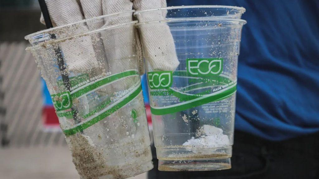 Vasos plásticos transparentes con etiquetas verdes que promocionan productos ecológicos, en una imagen que ilustra el debate sobre el greenwashing